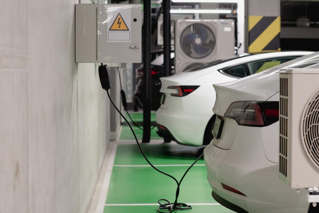 Technical diagram showing EV charging site grid connection with transformer, battery storage system, and multiple DC fast chargers with power flow arrows — clean engineering style, white background, blue/gray color palette Technical diagram showing EV charging site grid connection with transformer, battery storage system, and multiple DC fast chargers with power flow arrows — clean engineering style, white background, blue/gray color palette