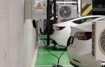 Technical diagram showing EV charging site grid connection with transformer, battery storage system, and multiple DC fast chargers with power flow arrows — clean engineering style, white background, blue/gray color palette